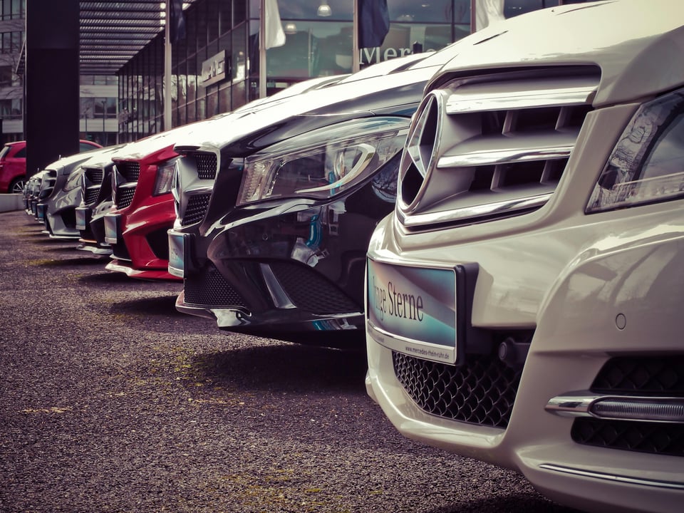 Row of Mercedes-Benz cars parked at a dealership