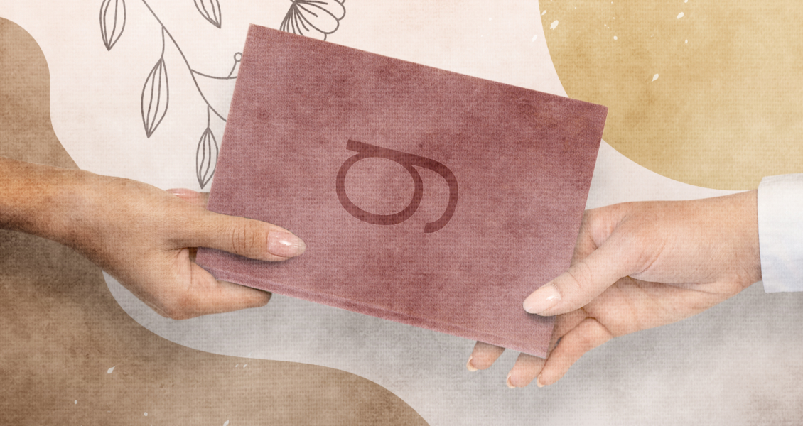 Two people exchanging a burgundy book with an abstract design in the background.