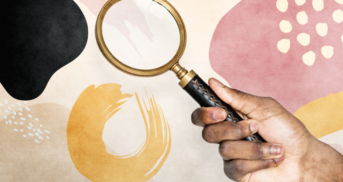 A hand holding a magnifying glass against an abstract background with colored shapes.