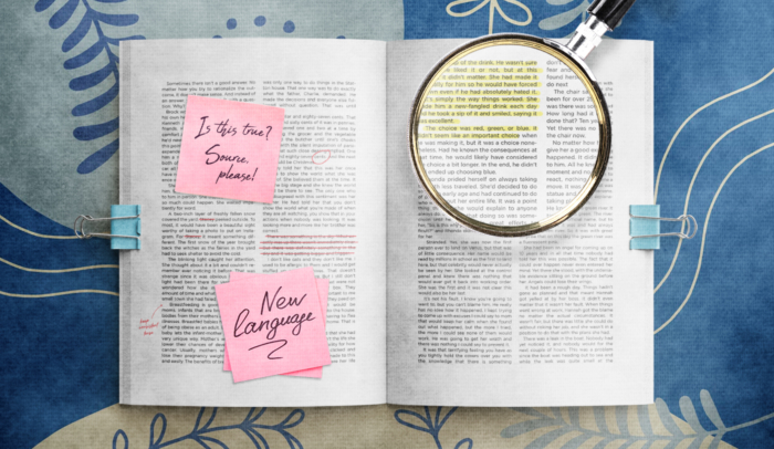 book pages with sticky notes and magnifying glass over text