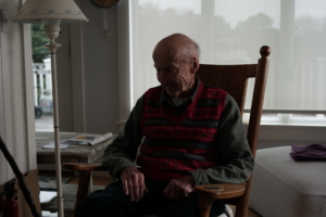 charles daly sitting in a chair